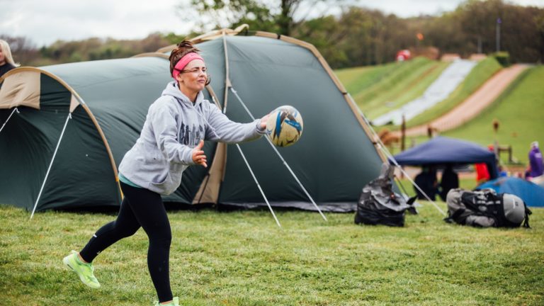 Camping   girl throwing rugby ball